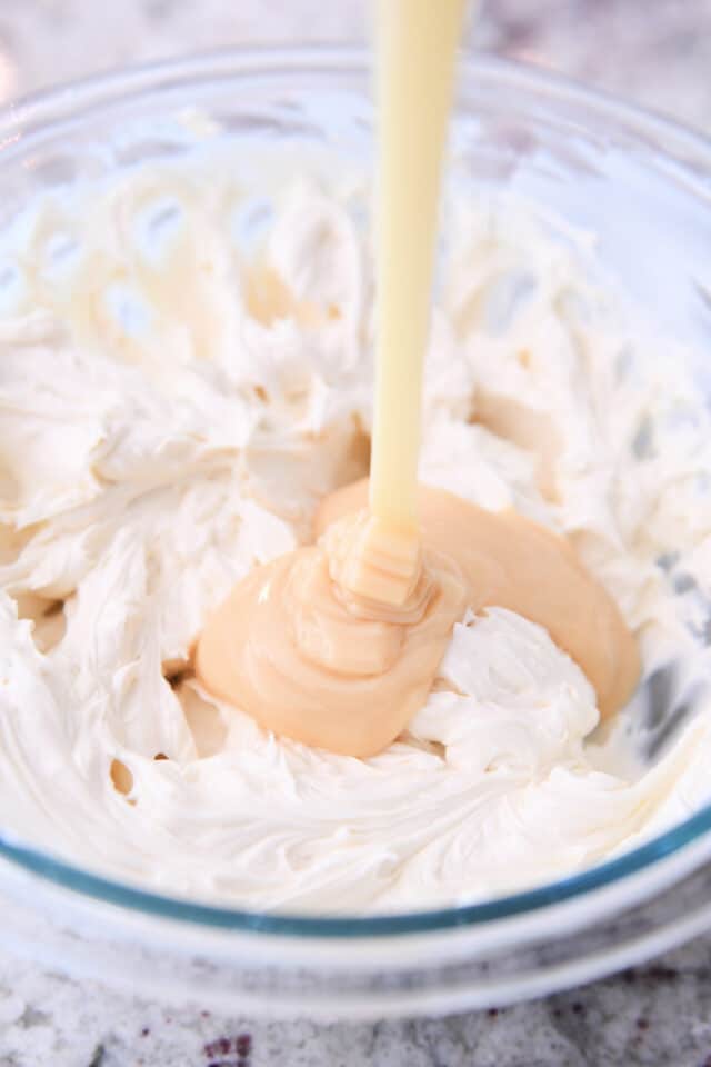 Drizzling sweetened condensed milk in cheesecake batter.