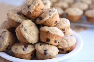 Stack of mini banana chocolate chip muffins on white plate.