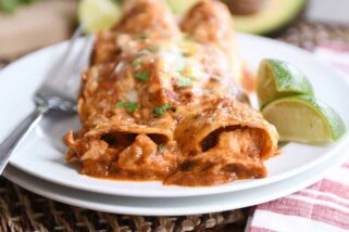 Two of the best red sauce chicken enchiladas on white plate.