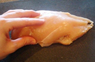 Sealing Chicken raw chicken breast on a black cutting board
