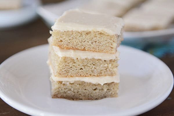A stack of iced banana bars on a white plate.