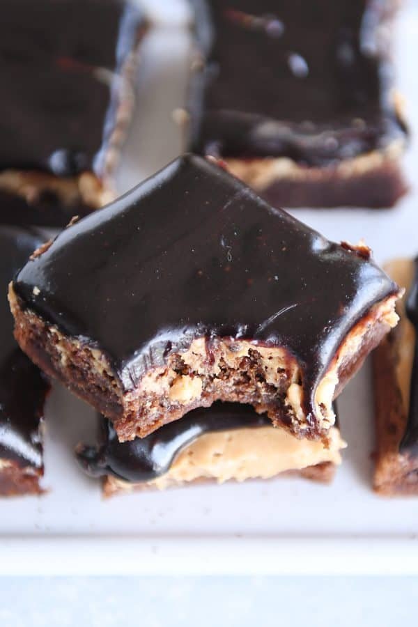 Stack of peanut butter marshmallow fudge brownies with bite taken out.