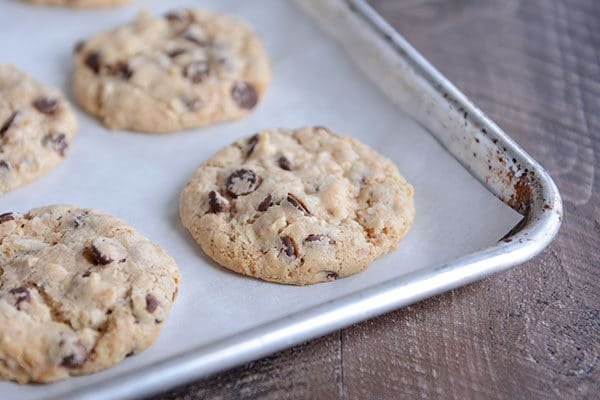 Chocolate chip cookies on a parchment-lined cookie sheet.
